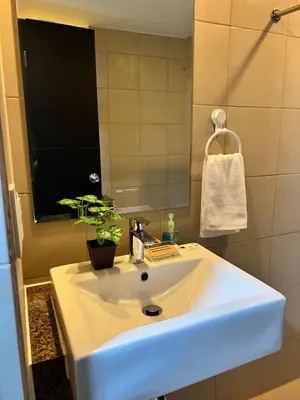 a bathroom with a white sink and a mirror at Brand New Studio w/ Washer in Manhattan Plaza Tower ll in Manila