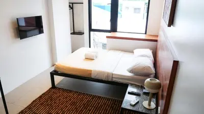 a small bed in a room with a window at Cayco House by Hotel Durban in Manila