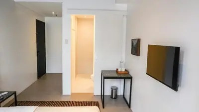 a living room with a table and a television on a wall at Cayco House by Hotel Durban in Manila