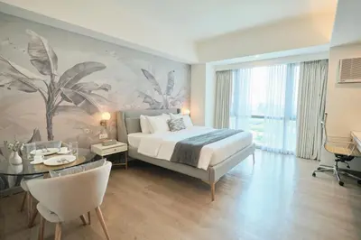a hotel room with a bed and a table and a dining room at BGC Suite with Golf Course View in Manila