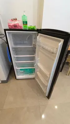 an empty refrigerator with its door open in a kitchen at Masterpiece Staycation Makati in Manila