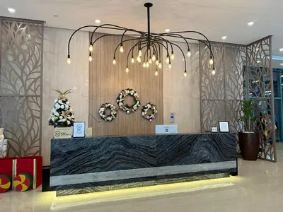 a lobby with a reception desk with a chandelier at Deluxe Suite in One Uptown, BGC with Mall Fountain View in Manila