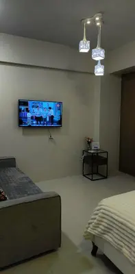 a bedroom with a flat screen tv on the wall at Palm Tree Villas - Studio Unit in Manila
