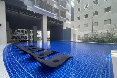 a large swimming pool with blue tiles in a building at Premier Luxury Suite near SM Mall of Asia Arena & DFA with Free Parking in Manila