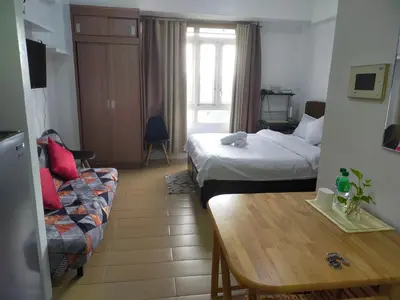 a room with two beds and a table and a couch at Rose condotel Newport in Manila