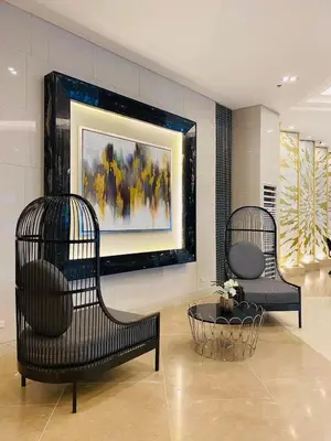 two chairs in a lobby with a painting on the wall at Connie's Fame Residence City Haven in Manila