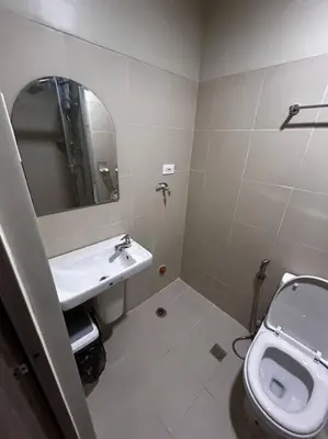 a bathroom with a sink and a toilet and a mirror at Connie's Fame Residence City Haven in Manila