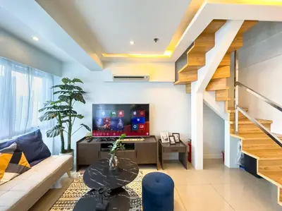 a living room with a couch and a tv at A2J Luxury 2BR BGC Suite Near High Street, Malls in Manila