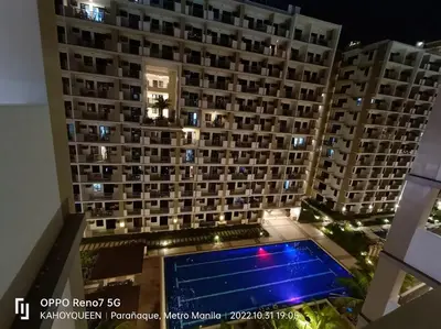 a large building with a swimming pool in front of it at Luxury 1 BR Suite Near NAIA in Manila