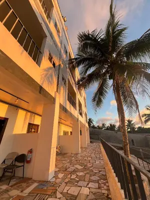 a building with a palm tree in front of it at Shiri Hotel in Silang