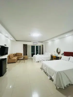 a hotel room with two beds and a couch at Shiri Hotel in Silang