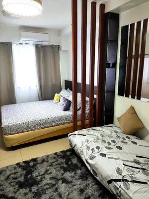 a bedroom with two beds and a mirror at Shore 2 Residences T1, MoA WTC SMX Arena 1br 4pax in Manila
