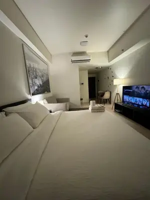 a bedroom with a large white bed and a television at 81 Newport Blvd Cluster 4 Unit B 3rd flr by Rechelle Nunag in Manila