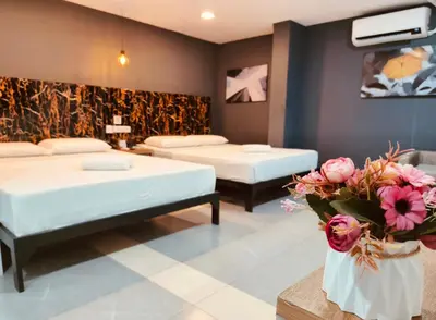 a room with two beds and flowers in it at Maine City Residences Tramo in Manila