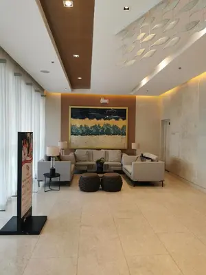a living room with couches and a painting on the wall at Shore 3 in Manila