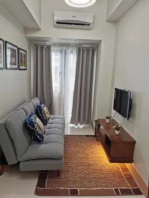 a living room with a couch and a tv at Shore 3 in Manila