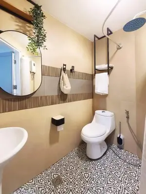 a bathroom with a toilet and a sink and a mirror at BGC - Two Bedroom Condo with Game Room high speed WiFi in Manila