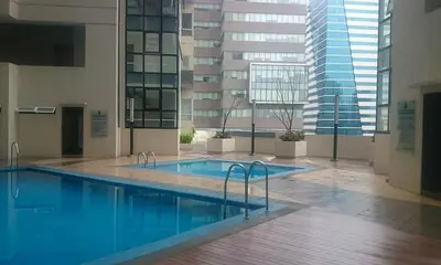 a large swimming pool in a building with a large window at BGC - Two Bedroom Condo with Game Room high speed WiFi in Manila