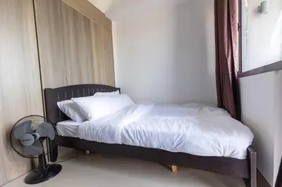 a bed in a room with a fan next to it at Bohemian 1-BR Condo in Mandaluyong in Manila