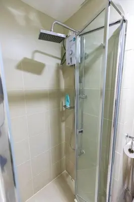 a shower with a glass door in a bathroom at Bohemian 1-BR Condo in Mandaluyong in Manila