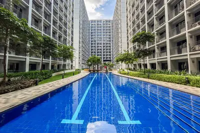 a large blue swimming pool in a city with tall buildings at MALL OF ASIA Condo with Balcony Facing Pool @ Shore2 in Manila