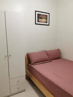 a small bedroom with a bed and a cabinet at Shore 3 residence in Manila