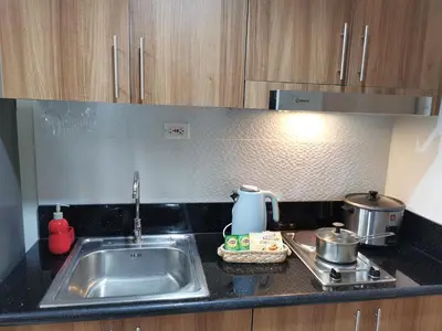 a kitchen counter with a sink and a stove at Shore 3 residence in Manila