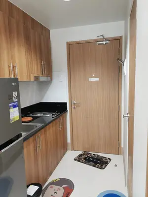 a kitchen with a wooden door and a counter top at Shore 3 residence in Manila