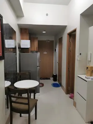 a kitchen with a table and chairs and a refrigerator at Shore 3 residence in Manila