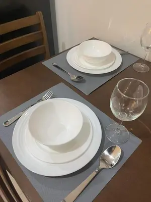 a table with two white plates and forks and spoons at Casa Florencia in Manila