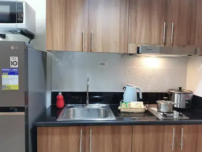 a kitchen with a sink and a microwave at Good Day staycation shore 3 in Manila