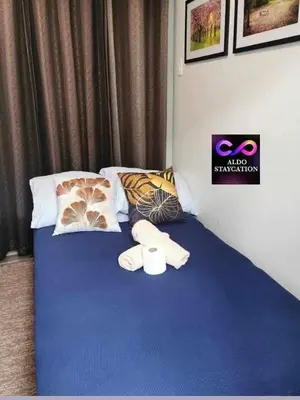 a blue bed with pillows and towels on it at Good Day staycation shore 3 in Manila