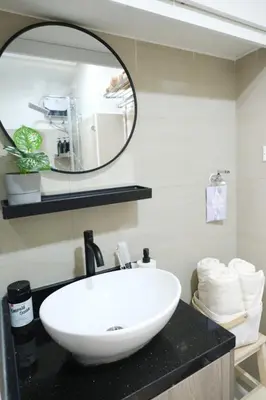 a bathroom with a white sink and a mirror at Modern Studio Condo near Mall of Asia & Airport, Shore 2 Residences in Manila