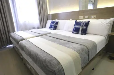 a bedroom with two beds with blue and white pillows at Modern Studio Condo near Mall of Asia & Airport, Shore 2 Residences in Manila
