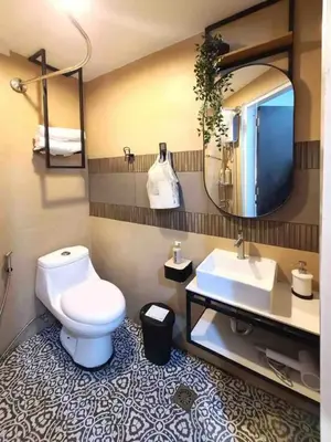a bathroom with a toilet and a sink and a mirror at BGC - Two Bedroom Condo with Game Room with 400mbps WiFi- 09 in Manila