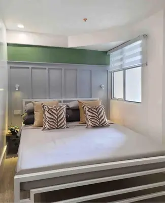 a large bed with pillows on it in a room at BGC - Two Bedroom Condo with Game Room with 400mbps WiFi- 09 in Manila