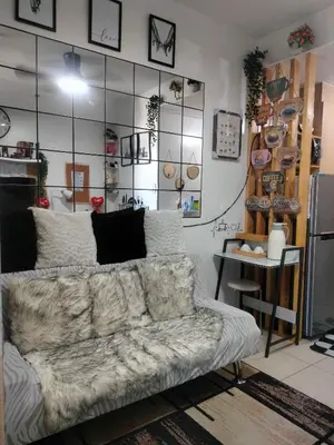 a living room with a couch and a large mirror at Smdc Breeze Residence in Manila