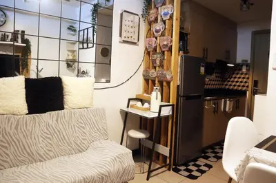 a living room with a couch and a refrigerator at Smdc Breeze Residence in Manila