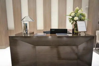 a reception desk with a laptop and a vase of flowers at Eighty One Building C53J Condotel in Manila