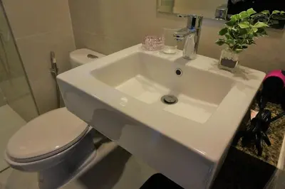 a bathroom with a white sink and a toilet at Eighty One Building C53J Condotel in Manila