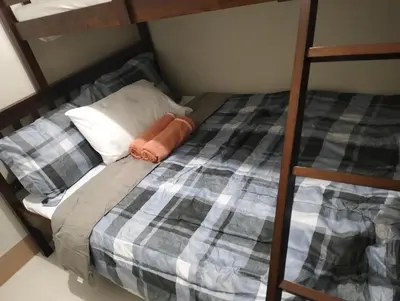 a bedroom with a bunk bed with a ladder at Cozy Condo near Mall of Asia in Manila