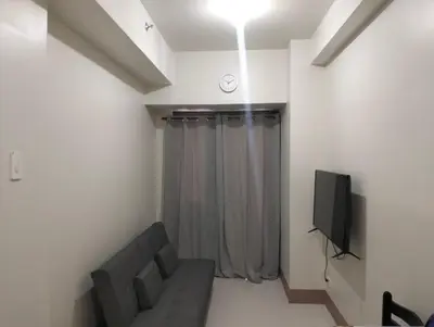 a living room with a couch and a tv at Cozy Condo near Mall of Asia in Manila