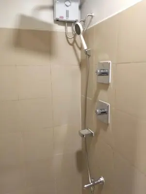 a shower with a shower head in a bathroom at Cozy Condo near Mall of Asia in Manila