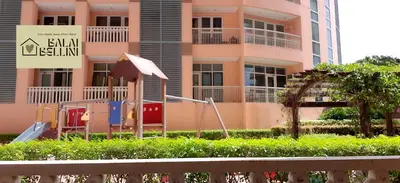 a pink apartment building with an umbrella and a playground at Condo in McKinley Hill near Grand Canal Mall (Balai Bellini) in Manila