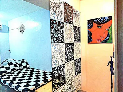a room with a checkered wall with a couch and a painting at Backpackers Transient Room in Manila