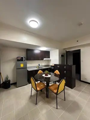 a kitchen and dining room with a table and chairs at The Ivory San Lorenzo Place Makati in Manila