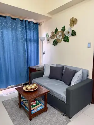 a living room with a couch and a table at Bayfront Suite in Pasay Near NAIA Terminal, PICC, Star City, MOA and US Embassy - Pet-Friendly, Wi-Fi & Netflix, Free Swimming Pool, Sauna and Gym, Work from Home Ready in Manila