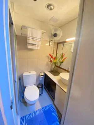 a small bathroom with a toilet and a sink at Macc Staycation Shell Residences Moa in Manila