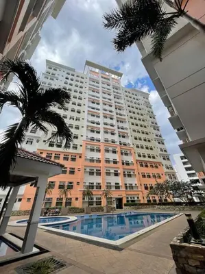 a large apartment building with a pool in front of it at Condo in Malate Manila in Manila