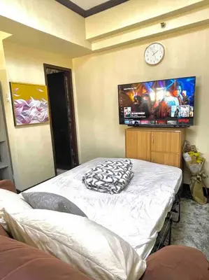 a room with a bed with a clock on the wall at Condo in Malate Manila in Manila